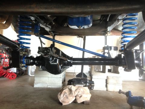 1979 Ford Bronco - The rear axle and suspension system of a vehicle are shown, with new blue coil springs installed.