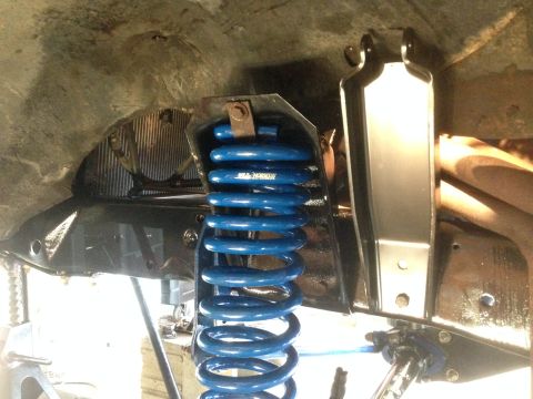 1979 Ford Bronco - Close-up of a blue coil spring suspension part, possibly from a vehicle, with 'JBA HORSEPOWER' visible on the spring.