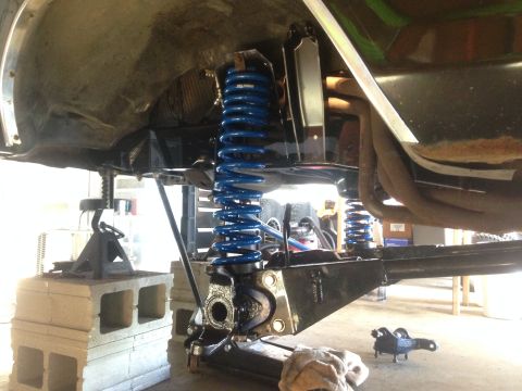 1979 Ford Bronco - Vehicle suspension components, including blue coil springs, are visible during a repair.