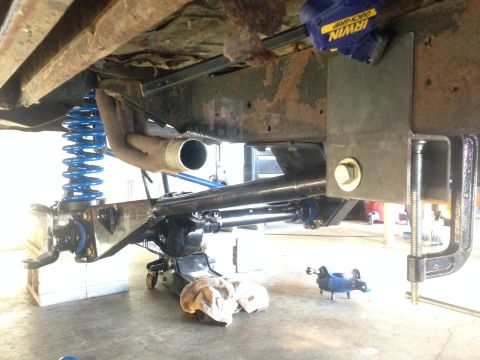 1979 Ford Bronco - Custom suspension components are being installed on a vehicle, supported by a jack.