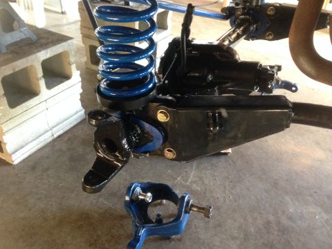 1979 Ford Bronco - Close-up of vehicle suspension components, including a blue coil spring and black metal parts.