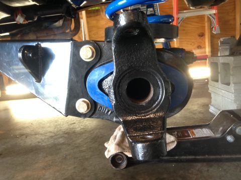 1979 Ford Bronco - A close-up view of a vehicle's suspension system, highlighting a black component with a blue spring and visible text.