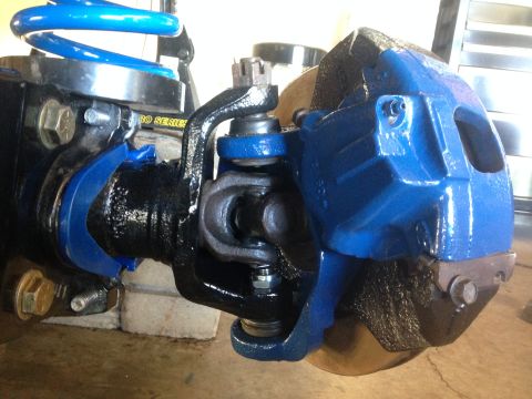 1979 Ford Bronco - This image shows a close-up view of a vehicle's suspension system, including a brake caliper and U-joint.