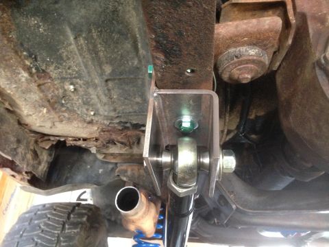 1979 Ford Bronco - Custom suspension bracket installed on a vehicle frame with visible rust and a shock absorber.