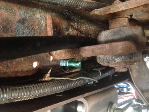 1979 Ford Bronco - This image shows a close-up view of aged and rusty vehicle suspension components, including a bolt and wiring.
