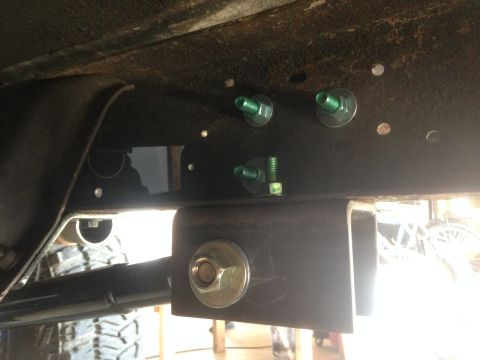 1979 Ford Bronco - Close-up view of vehicle frame and suspension hardware, with a tire visible in the background.
