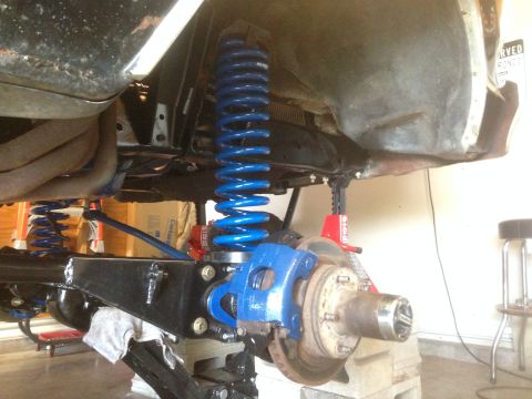 1979 Ford Bronco - The underside of a vehicle is shown with new blue suspension components and brake assembly.