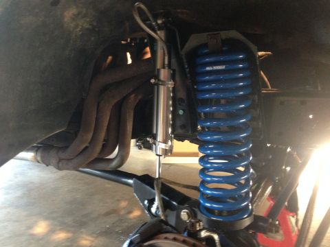 1979 Ford Bronco - The image shows a close-up view of a vehicle's suspension system, including a blue coil spring and shock absorber.