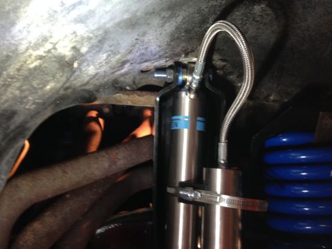 1979 Ford Bronco - Close-up of a Bilstein shock absorber and blue coil springs, likely part of a vehicle's suspension system.