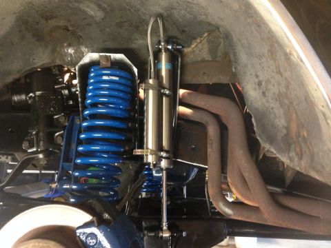 1979 Ford Bronco - The image shows a close-up of a vehicle's suspension system, a blue coil spring and a shock absorber.