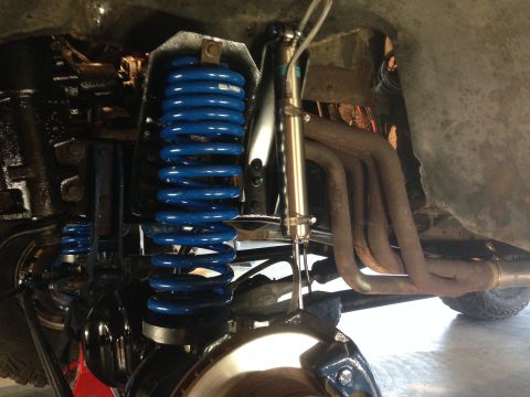 1979 Ford Bronco - The vehicle's suspension and exhaust components are visible from a low angle, showing aftermarket blue springs.