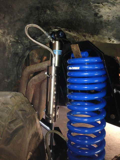 1979 Ford Bronco - Close-up of aftermarket blue coil springs and a Bilstein shock absorber, likely for an off-road vehicle.