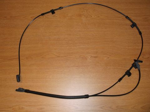 1999 Mercury Grand Marquis - long black parking/emergency brake cable with end fittings and a sensor connector, photographed on a wood floor.