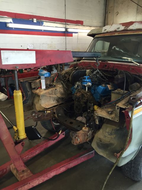 1978 Ford Bronco - The engine bay of a truck is shown with the front end partially removed for service.