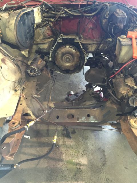 1978 Ford Bronco - The engine bay of a vehicle is shown with the transmission removed, revealing the frame and associated components.