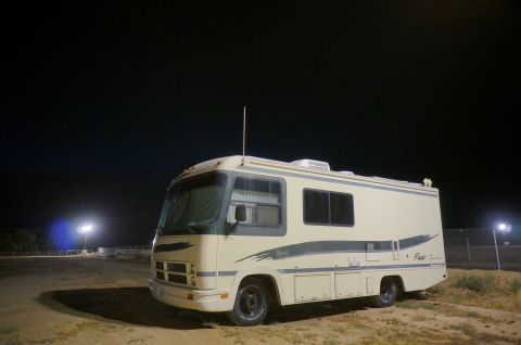 1995 Chevrolet P30 1 Ton - Step Van - Motorhome with "Flair" badging parked outdoors at night under artificial lights.