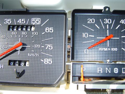 1986 Ford Bronco - Close-up of a vehicle's dashboard gauges, including the speedometer, tachometer, and gear selector display.