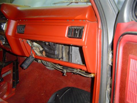 1986 Ford Bronco - The interior of a vehicle shows the dashboard with air vents and the heater core exposed.