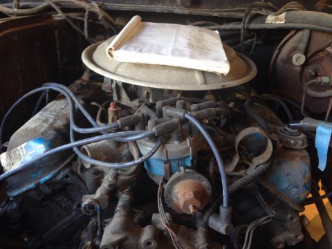 1979 Ford Bronco - A manual rests atop the air cleaner in this engine bay, obscuring some details.