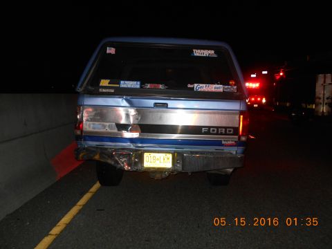 1996 Ford F-250 - A damaged Ford pickup truck is seen at night on a highway, with emergency lights in the distance.