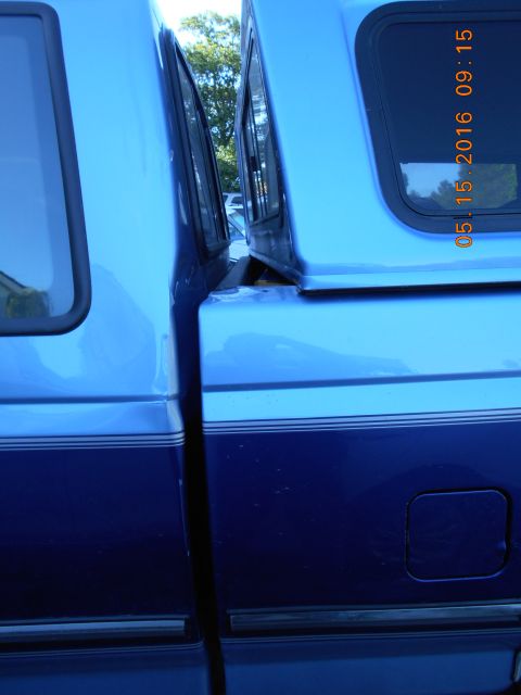 1996 Ford F-250 - A blue pickup truck with a camper shell is viewed from the side, revealing its two-tone paint scheme.