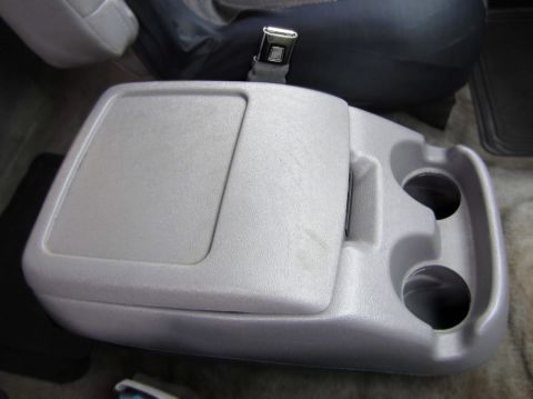 1996 Ford Bronco - Interior view of a gray center console, dual cup holders and a storage compartment.