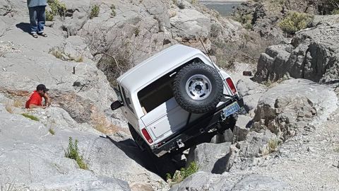 1979 Ford Bronco - White 1979 Ford Bronco navigating a steep, rocky off-road path.