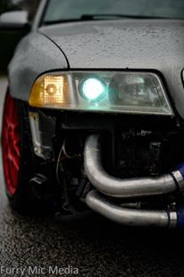 2001 Audi S4 - Close-up of the front of a silver car, showing custom intercooler piping and a glimpse of a red wheel.