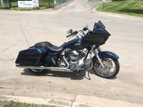 2004 Harley-Davidson Fat Boy - Dark blue Harley-Davidson touring motorcycle parked on pavement with a building and trees in the background.