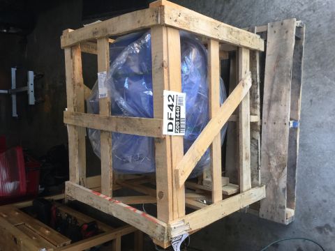 1978 Ford Bronco - A blue engine is secured within a wooden crate, ready for transport or storage.