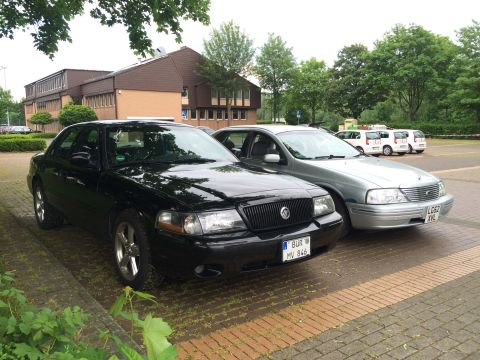 1999 Ford Fairlane - A black Mercury Marauder is parked next to a silver sedan in a parking lot.