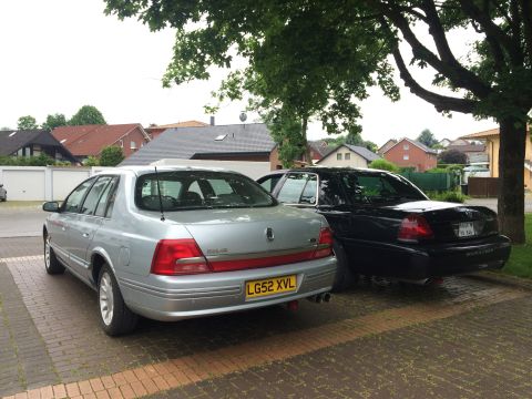 1999 Ford Fairlane - Two sedans, one silver and one black, are parked side-by-side on a paved driveway.