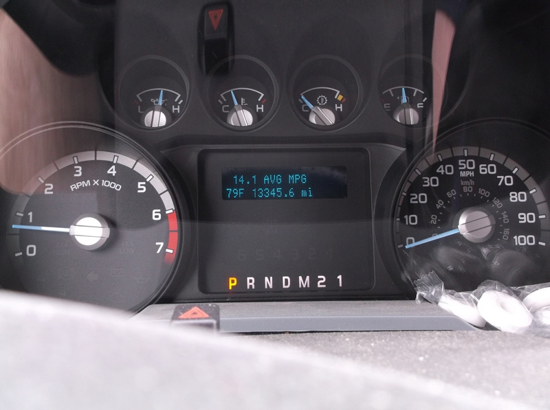 Dashboard gauges showing RPM, MPH, fuel, and temperature; digital display shows 14.1 AVG MPG and 79F 13345.6 mi
