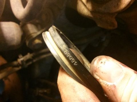 1996 Ford Bronco - A mechanic holds a part stamped with the numbers 15652, likely a replacement component for a vehicle's suspension system.