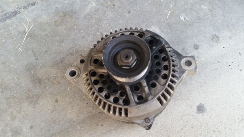 1992 Ford Bronco - This is an alternator, likely from a Ford vehicle, shown on a concrete surface.