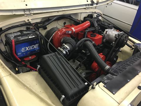 1986 Jeep Wagoneer - The engine bay of a Jeep shows a modified engine with a prominent turbocharger and updated components.