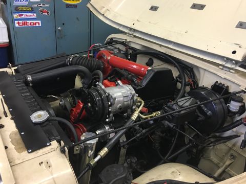 1986 Jeep Wagoneer - The engine bay of a Jeep shows various components including the air intake, AC compressor, and brake booster.