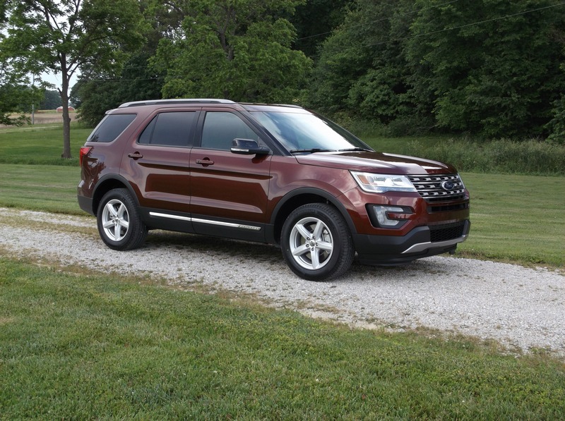Reddish-brown Ford Explorer SUV, 3q-front view, parked on gravel driveway
