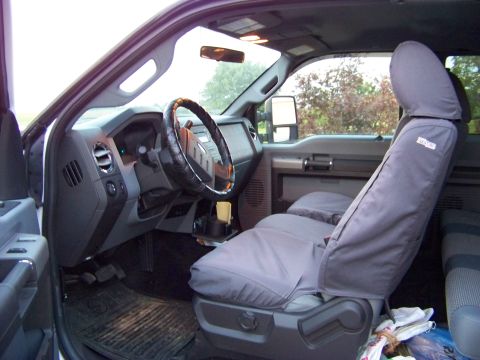 2011 Ford F-250 - The interior of a truck is shown, seat covers and a steering wheel cover.