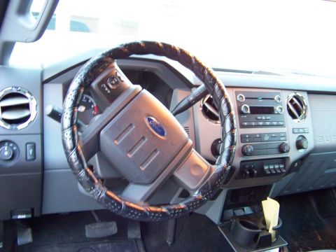2011 Ford F-250 - The interior of a 2011 Ford F-250 is visible, focusing on the steering wheel and dashboard controls.