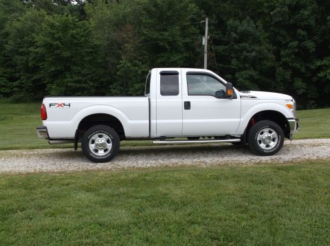 2011 Ford F-250 - This white 2011 Ford F-250 Super Duty pickup truck is shown from the side.