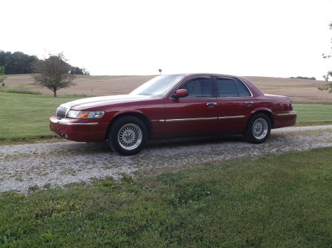 1999 Mercury Grand Marquis - Maroon 1999 Mercury Grand Marquis sits on a gravel driveway in front of a rural field.