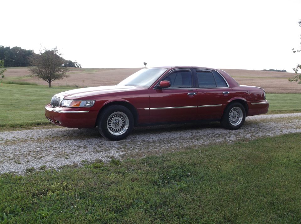 1999 Mercury Grand Marquis parked on a gravel driveway with a field in the background