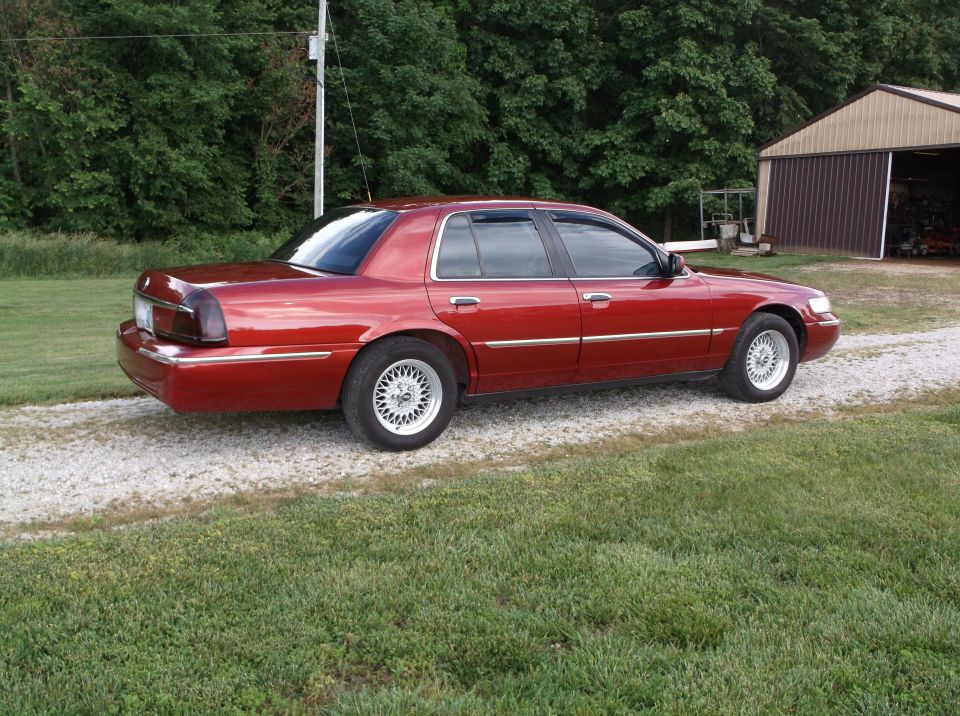 1999 Mercury Grand Marquis parked on gravel with a barn in the background