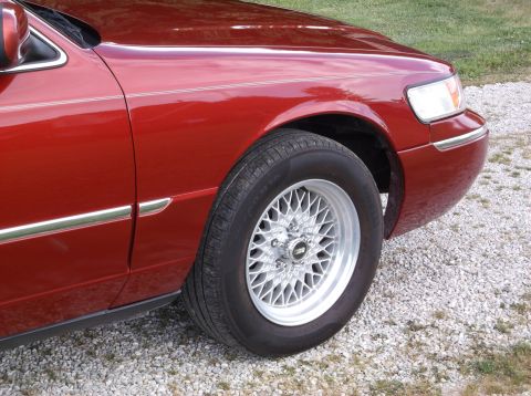 1999 Mercury Grand Marquis - A red 1999 Mercury Grand Marquis is shown from the front quarter panel to the front bumper.