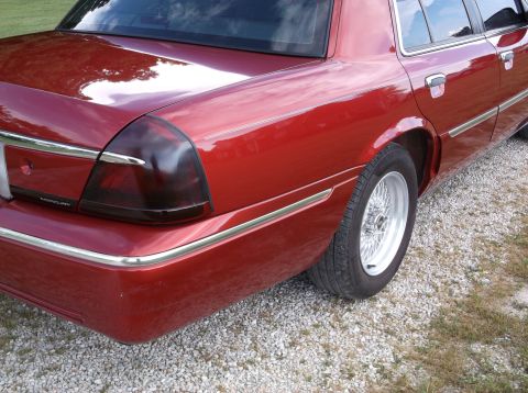 1999 Mercury Grand Marquis - Rear view of a red 1998 Mercury Grand Marquis with chrome trim and wire wheels.