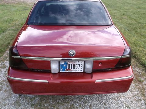 1999 Mercury Grand Marquis - The rear of a red Mercury Grand Marquis LS sedan is shown, tinted taillights and an Indiana license plate.