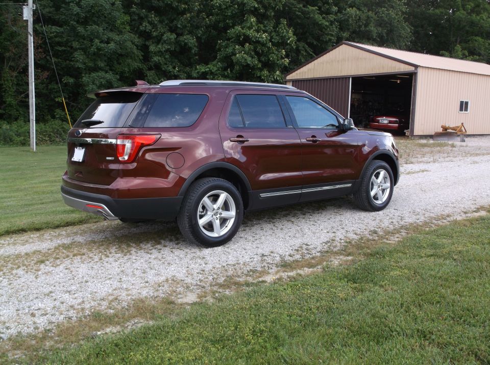 Maroon Ford Explorer parked on a gravel driveway, rear-left quarter view