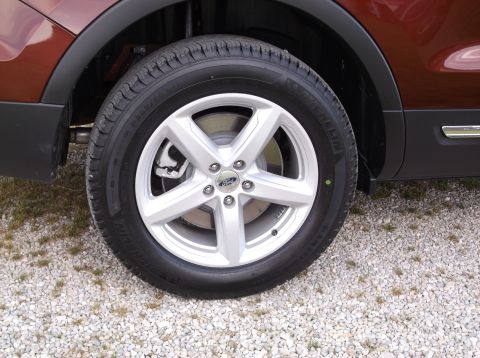 2016 Ford Explorer - Close-up of the front wheel assembly on a 2016 Ford Explorer, a silver 5-spoke alloy rim and a Michelin tire.