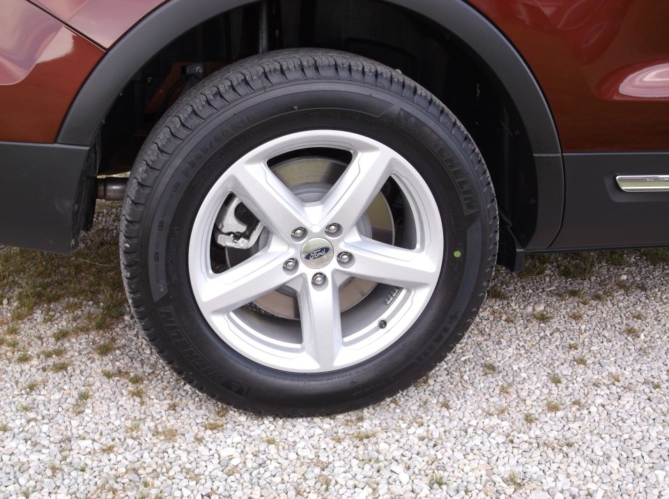 Front wheel of a 2016 Ford Explorer with a silver 5-spoke rim and Michelin tire